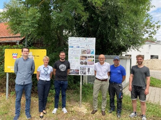 Julian Eckert und Prof. Dr. Sabine Grüner-Lempart (von links) von der Hochschule Weihenstephan-Triesdorf (HWST) vor einer Tafel, die Interessierte über das Projekt „PlasticWorms“ informiert. Die Pilotanlage in der Gemeinde Petershausen soll im Herbst an den Start gehen. Das Bild außerdem (weiter von links) Markus Mostegel und Christian Männl von der ausführenden Partnerfirma ZWT, Franz Resner von den Eigenbetrieben der Gemeinde Petershausen (EGP) sowie Samuel Schmucker (HSWT). Foto: EGP