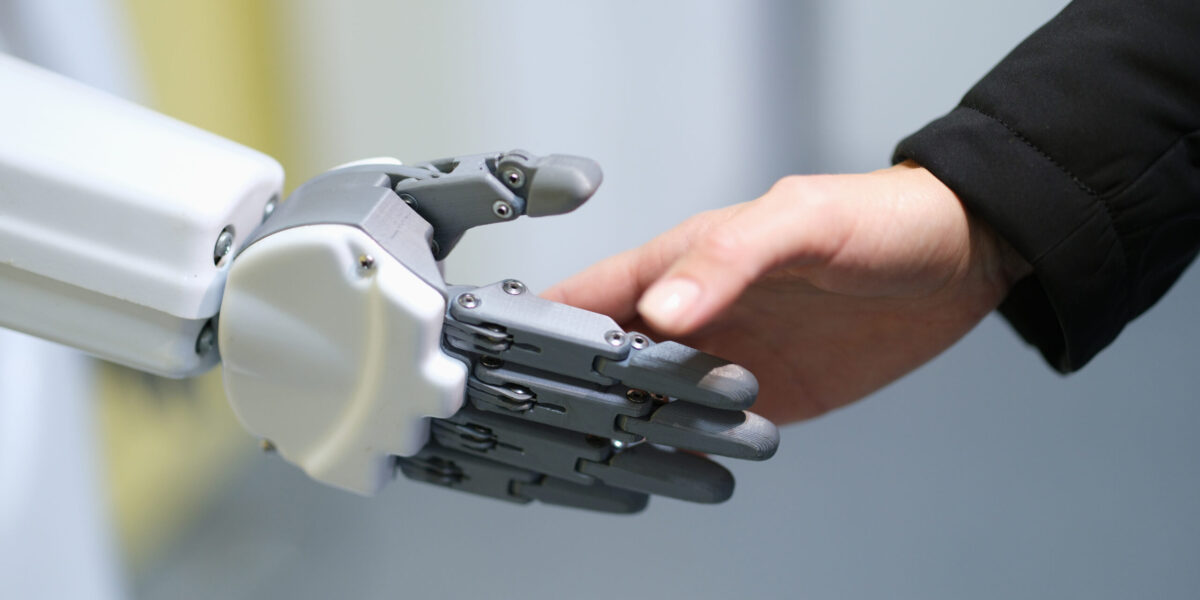 Roboter und Mensch schütteln sich die Hand