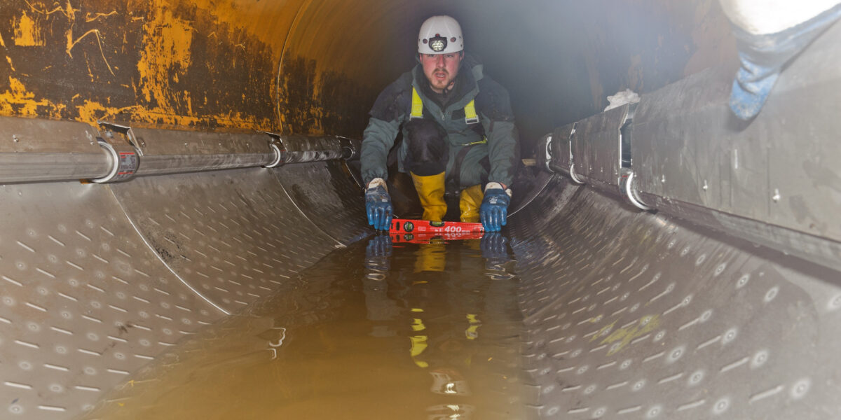 Ein Mitarbeiter der Installationsfirma Uhrig aus Geisingen in Baden-Württemberg stellt die druckdichten Verbindungen der jeweils 1m langen Wärmeübertragerelemente her. Auf diese Weise entstand ein insgesamt 15 m langer Wärmeübertrager in der Haltung des Michwasserkanals in Oldenburg, Niedersachsen, mit einem Durchmesser von 1,2 m. Foto: Michael Stefan/IRO