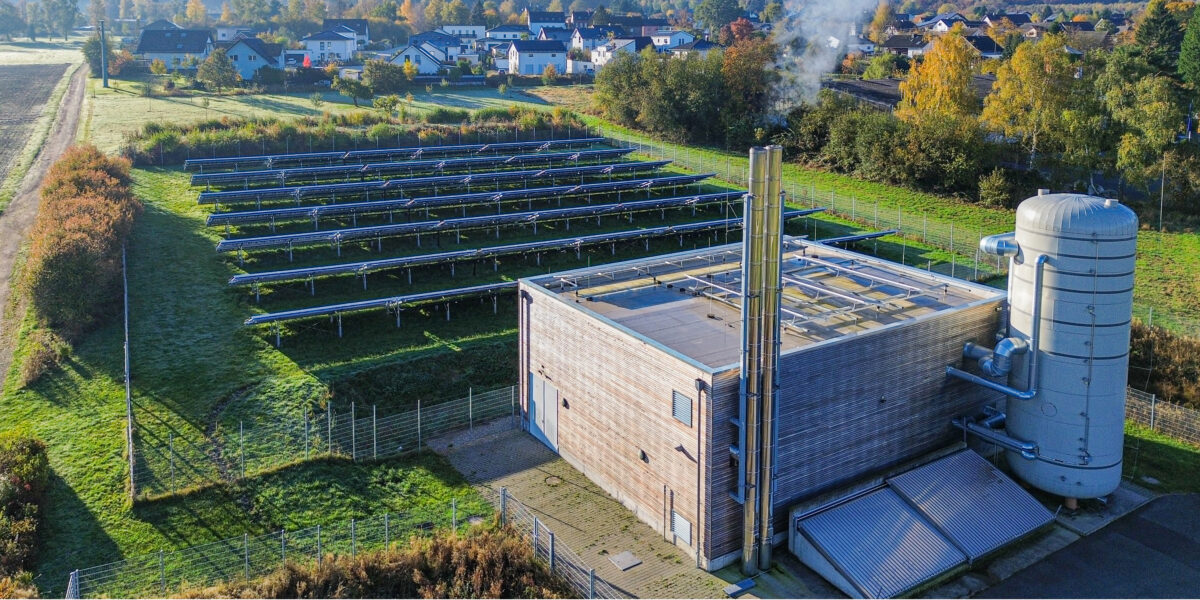 Die Heizzentrale der Ortsgemeinde Ellern liegt am Ortsrand. Rechts neben dem Gebäude sieht man den 105.000 Liter fassenden Pufferspeicher. Foto: Raab-Gruppe