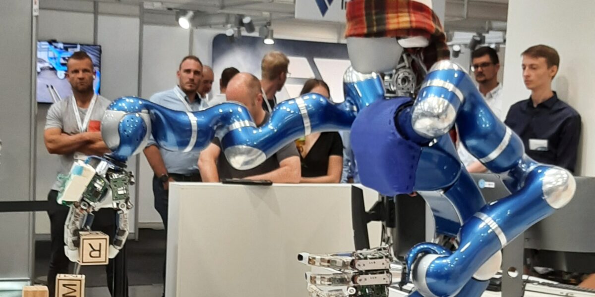 Schon lange vor Teslas humanoidem Roboter Optimus konnte der DLR-Roboter "Justin" Bälle fangen. Das Bild zeigt ihn auf der Messe Automatica 2022 in München, wo er Würfel zwischen seinen Fingern dreht und positioniert. Foto: M. Ciupek