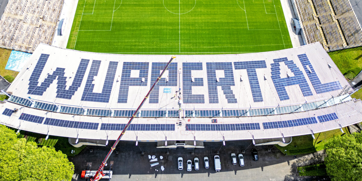 Ein Stück Energiewende auf dem Dach der Haupttribüne des Wuppertaler Stadions am Zoo. Genau 702 Photovoltaik-Module bilden den Schriftzug "WUPPERTAL. Am 18. April 2022 wurde termingerecht das letzte der Paneele montiert. Foto: Frank Buetz/Gebäudemanagement Stadt Wuppertal