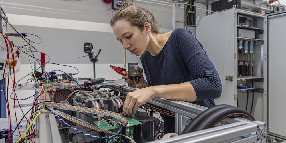 Am Fraunhofer-Institut für Solare Energiesysteme entwickeln Forschende eine Mittelspannungs-Systemtechnik für zukünftige Schnellladestationen. Das Bild zeigt eine Forscherin an einem Prototyp.