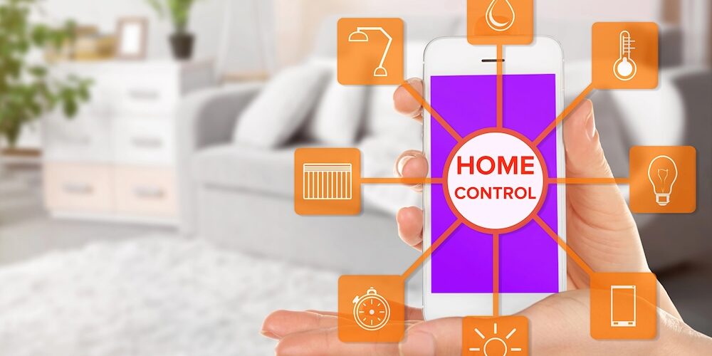 Blick auf ein Smartphone-Display, von dem aus verschiedene Icons die Nutzung von Smart-Home-Produkten symbolisieren. Im Hintergrund ist die Szenerie eines Wohnzimmers mit gemütlichem Sofa zu sehen.