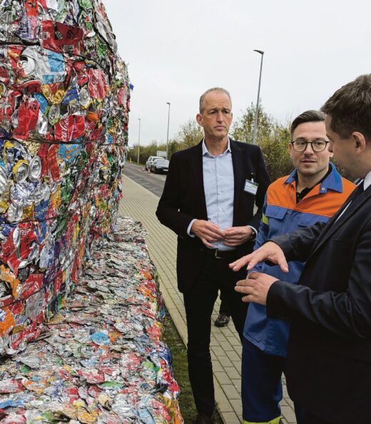 Vor einem Bigpack gepresster Getränkedosen: Folker Ohle (v.l.n.r.), Vice President von Novelis Europe, Werkleiter Christian Grossmann und Sven Schulze, Wirtschaftsminister von Sachsen-Anhalt. Foto: Manfred Schulze