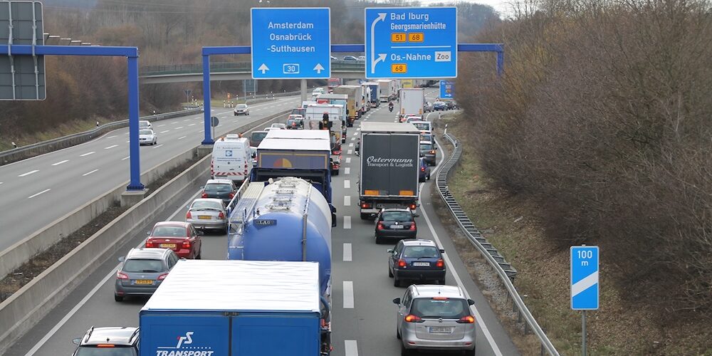 Blick auf eine Autobahn in Deutschland mit dichtem Verkehr. Rechts zweigt eine Abfahrt ab.